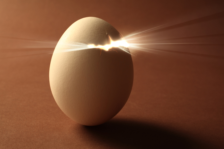 An egg cracking open with light bursting out