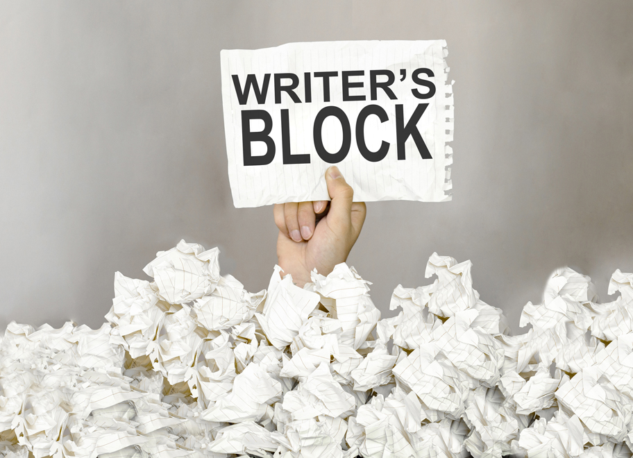 male hand with sign writers block coming out of used scrunched up paper on floor