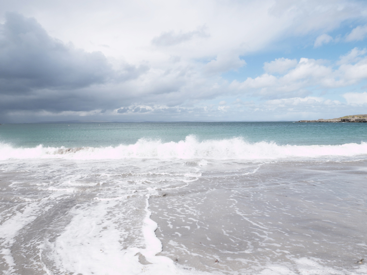 Waves breaking on shore with dramatic cloud formation
